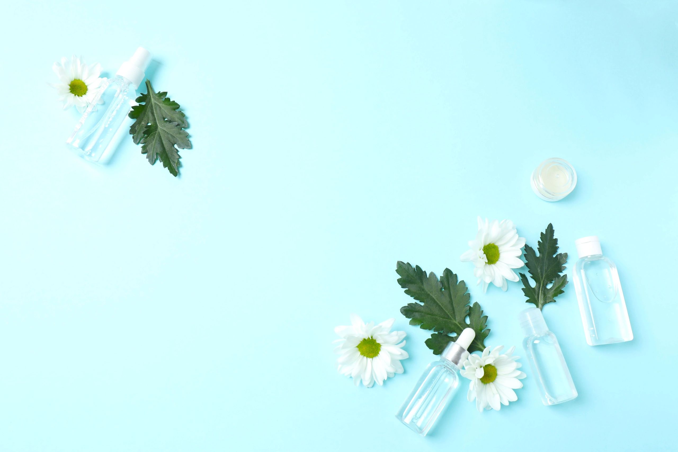 Cosmetic bottles with white chrysanthemum representing soothing botanicals
